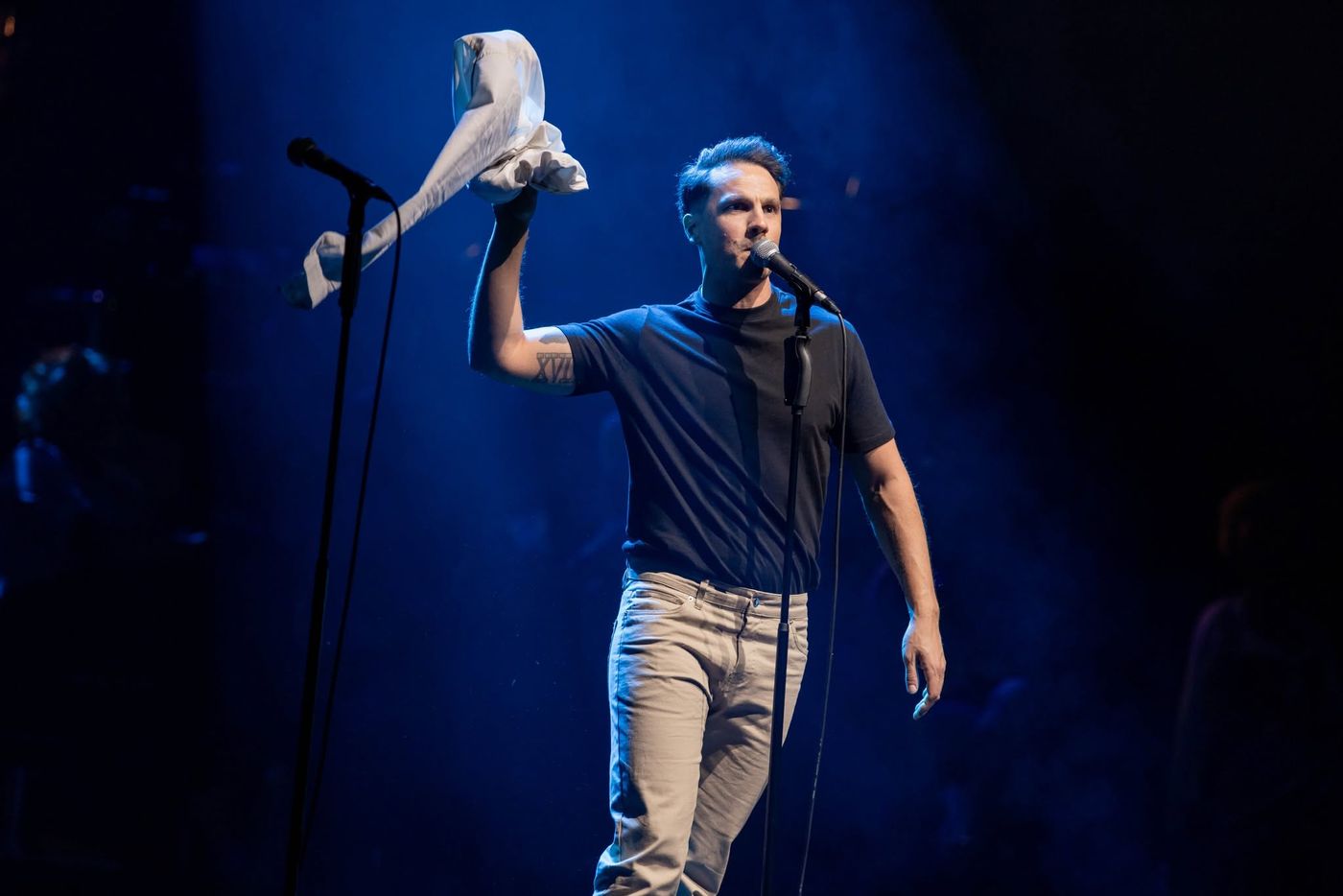 A performer holding a prop aloft mid-number