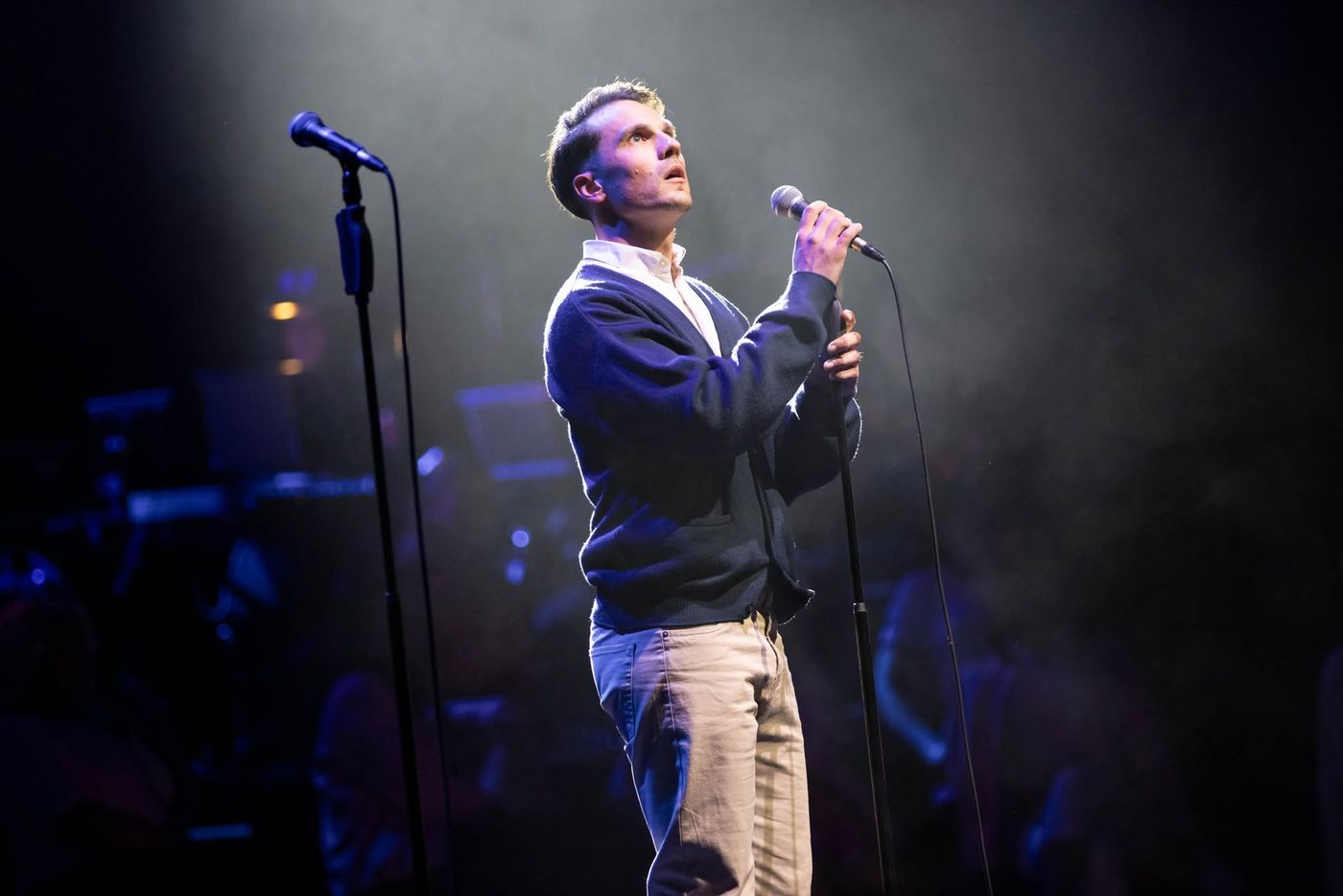 A performer singing alone in a spotlight